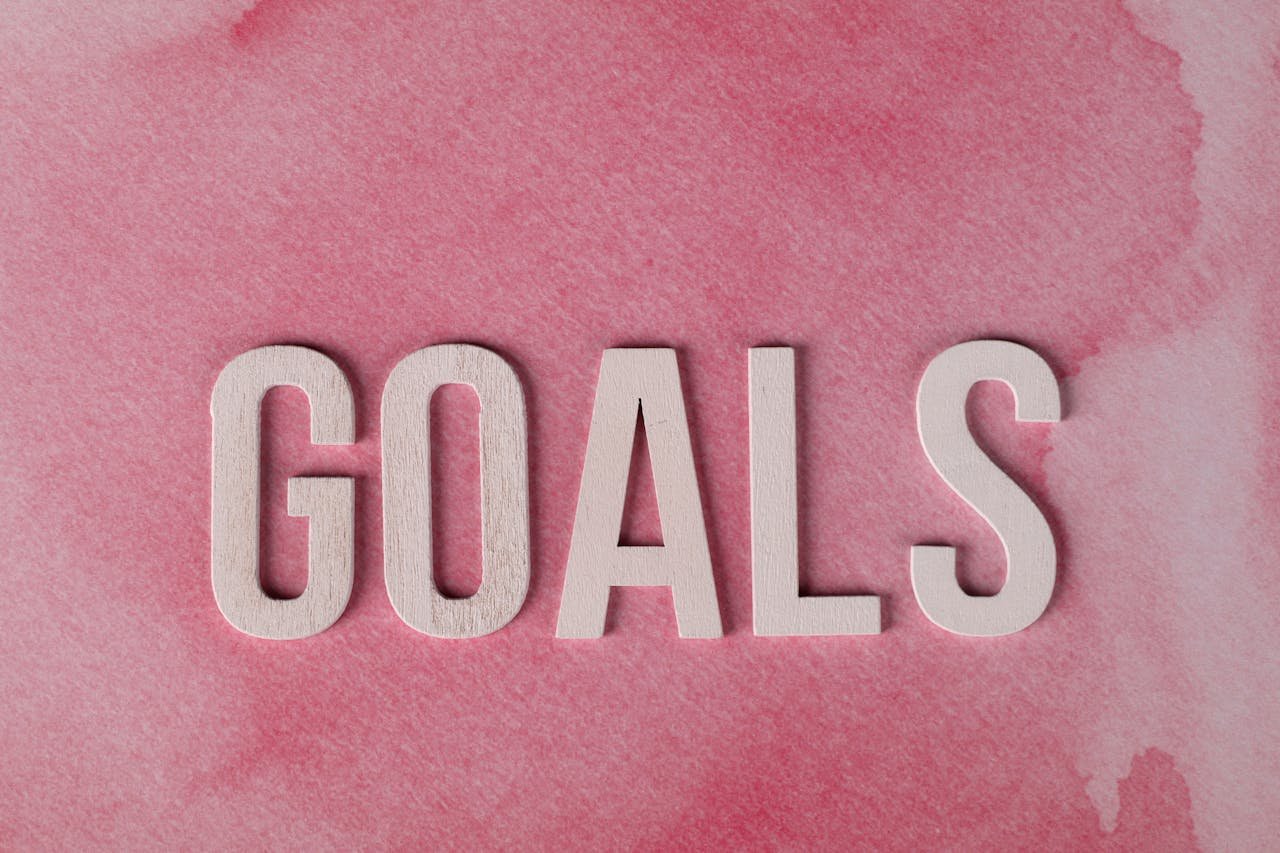hero-img-02 Motivational word GOALS on a pink watercolor background for inspiration.