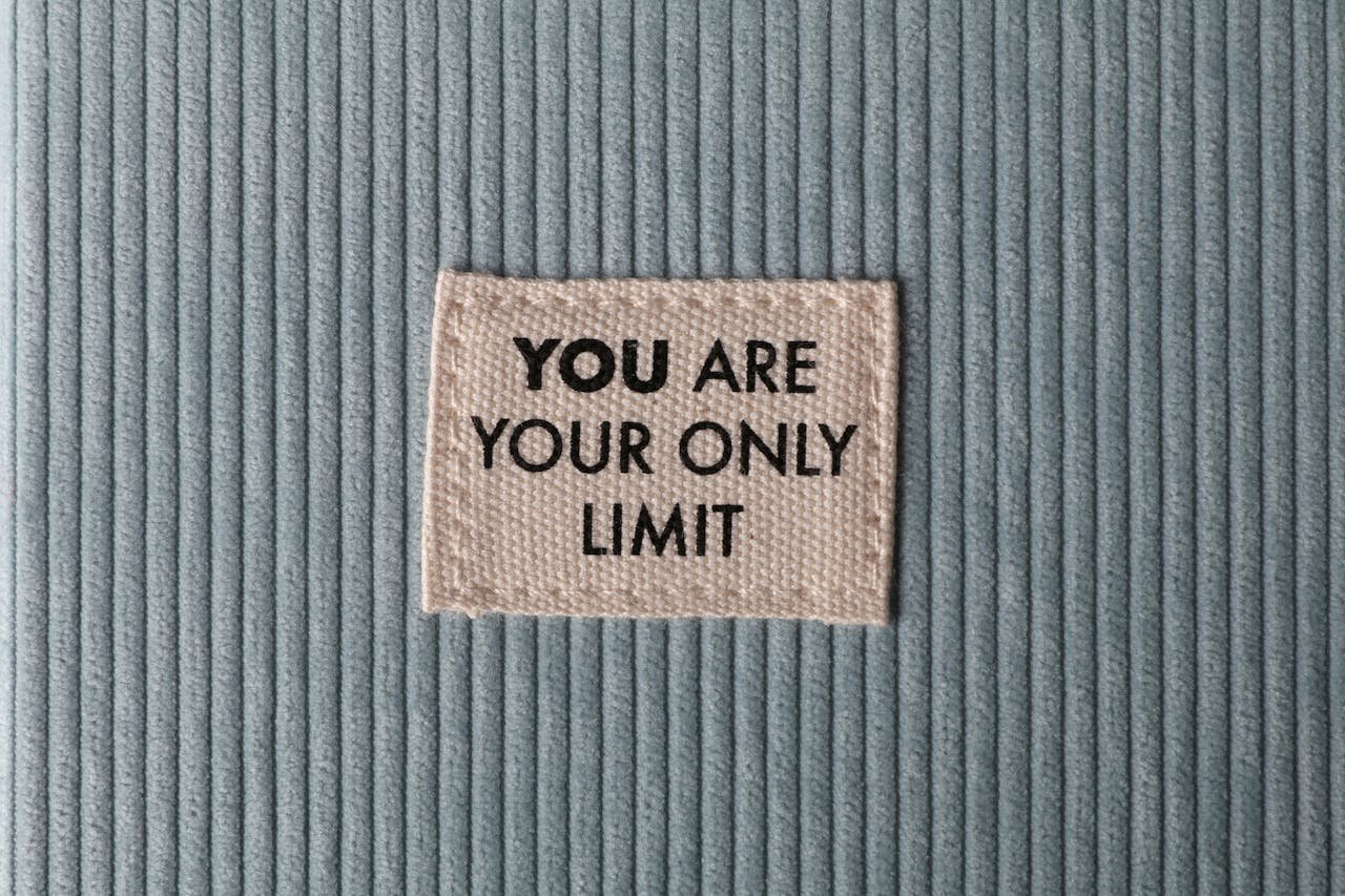 Fabric patch on blue velvet with motivational text You Are Your Only Limit in close-up view.